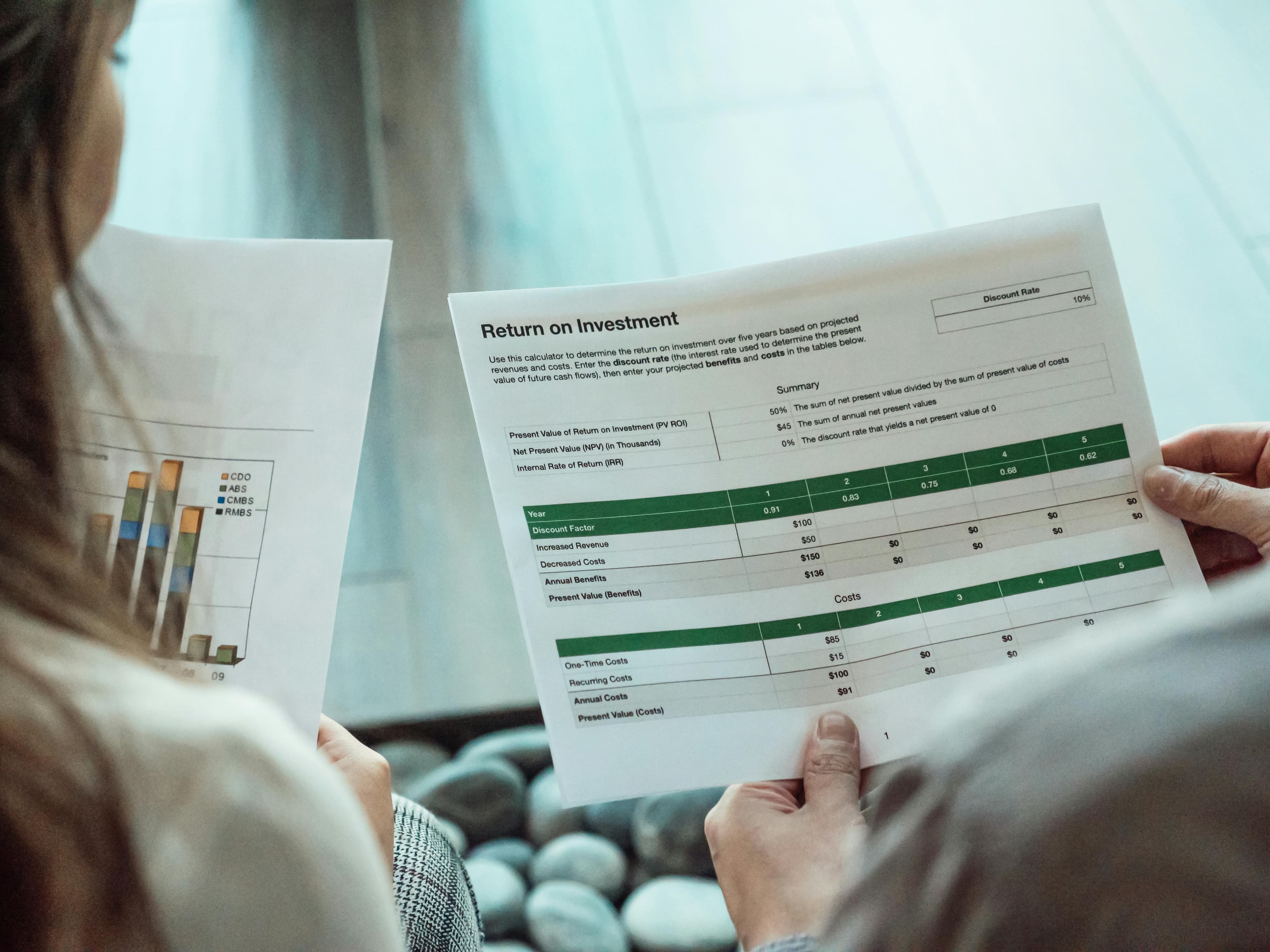 Two people reviewing an investment analysis report
